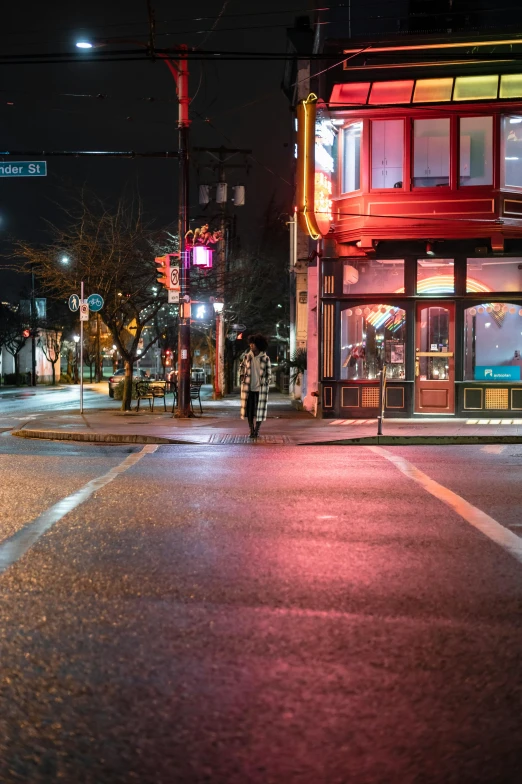 a person walking down a street at night, on a sidewalk of vancouver, intersection, empty streetscapes, capitol hill