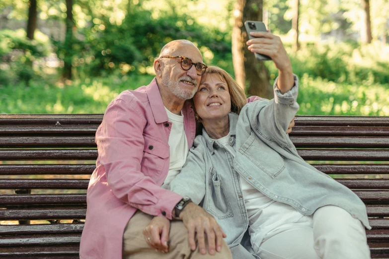 a man and woman sitting on a bench taking a selfie, older male, profile image, brown, uploaded