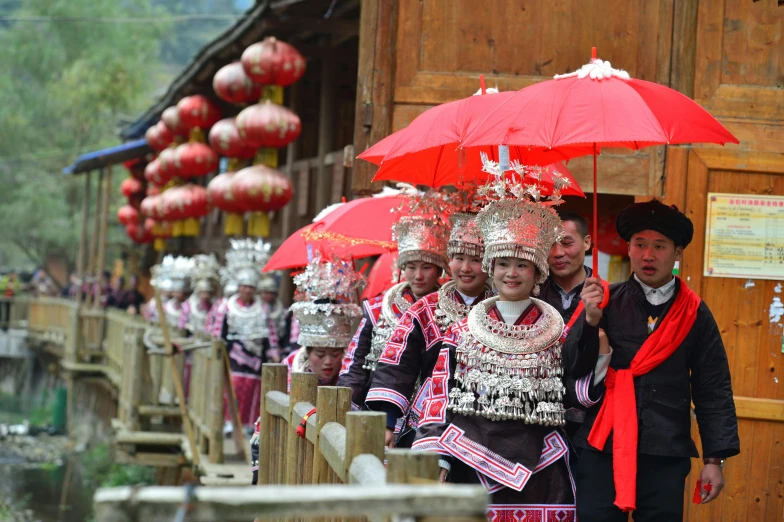 a group of people standing next to each other under red umbrellas, inspired by Miao Fu, tribal clothing, zhangjiajie, wearing an elaborate helmet, avatar image