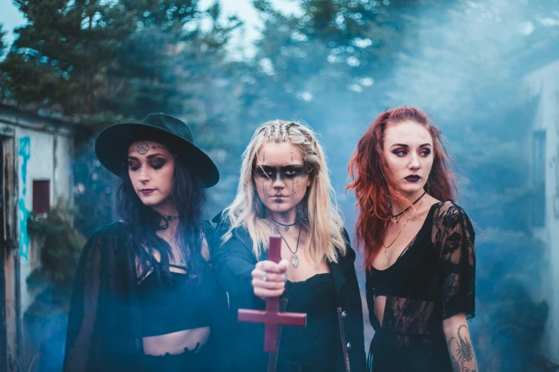 a group of women standing next to each other, unsplash, international gothic, band promo, witch hut, three women, ash thorp