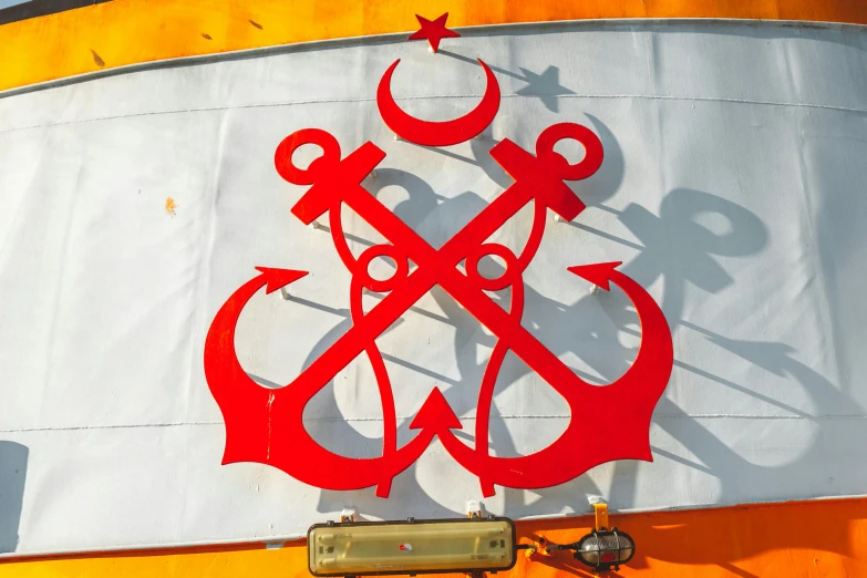 a close up of a sign on the side of a train, by Julia Pishtar, pexels contest winner, hurufiyya, masonic symbols, on a boat, red horns, three masts