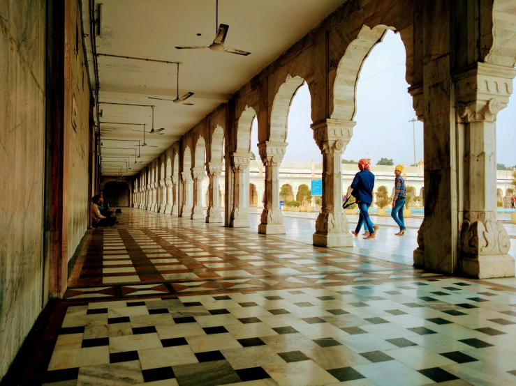 a couple of people walking down a hallway, bengal school of art, with beautiful mosques, pillars of marble, a cozy, sprawling