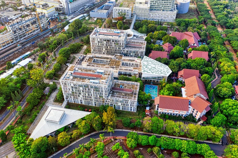 an aerial view of a large building surrounded by trees, a digital rendering, by Arthur Sarkissian, unsplash, south jakarta, medical complex, uhq, landscape architecture photo