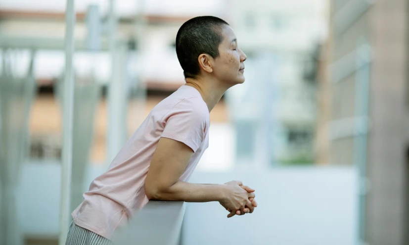 a man in a pink shirt looking off into the distance, inspired by Fei Danxu, happening, relaxed posture, profile image, an asian woman, a high angle shot