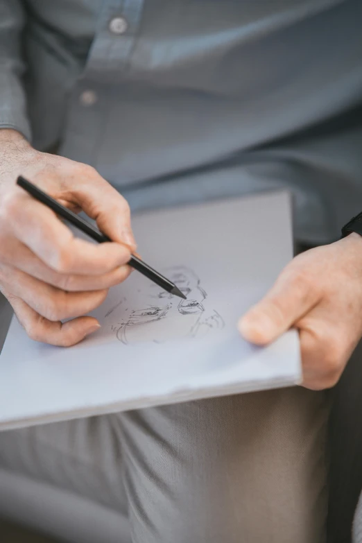 a man holding a pen and writing on a piece of paper, a drawing, pexels contest winner, visual art, caricature, elegant drawing, well drawn faces, professional picture