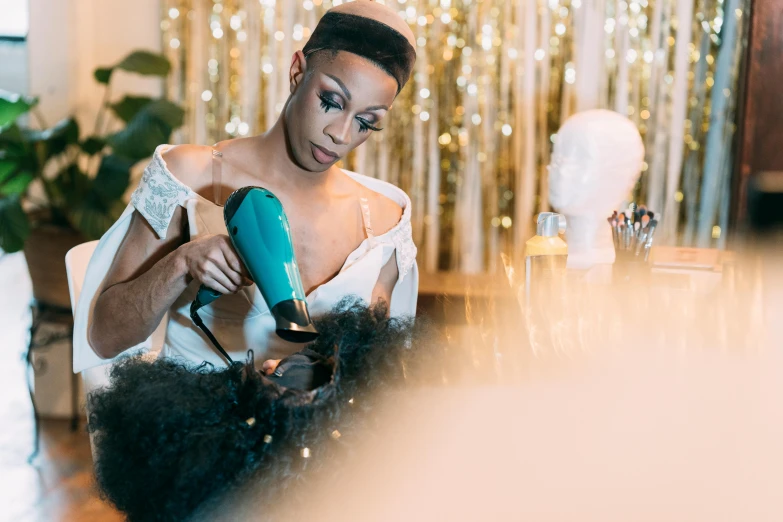 a woman blow drying her hair with a blow dryer, pexels contest winner, happening, gold and teal color scheme, d. i. y. venue, grace jones, glamorous setting