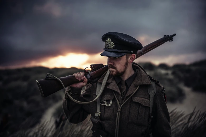 a man in a military uniform holding a rifle, an album cover, by Peter Churcher, unsplash, golden hour cinematic, historical reenactment, pokemon fighting at world war 2, 5 0 0 px