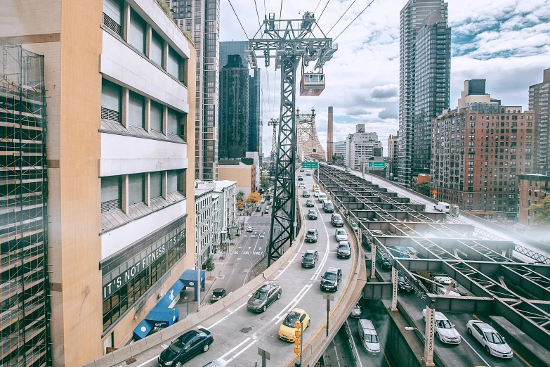 a street filled with lots of traffic next to tall buildings, a colorized photo, inspired by Thomas Struth, pexels contest winner, sky bridge, street tram, high bridges, wide high angle view