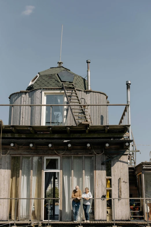 a couple of people standing on top of a building, solarpunk cantine, bay window, habl telescope, airbnb