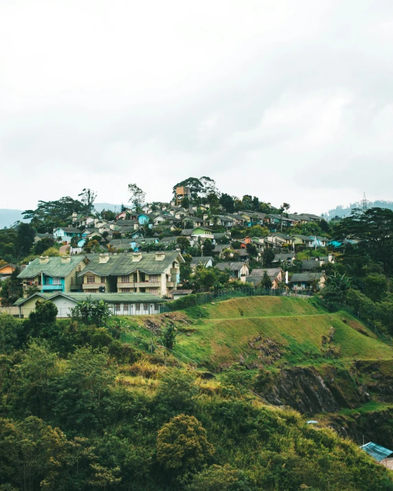 a group of houses sitting on top of a lush green hillside, by Jessie Algie, trending on unsplash, sumatraism, sri lanka, small town, leaked image, slide show