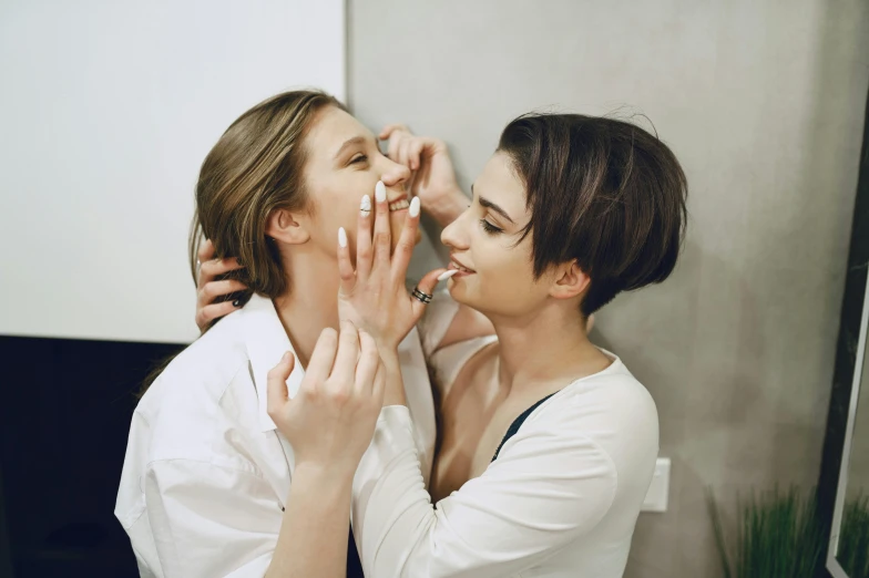 a woman putting makeup on another woman's face, by Emma Andijewska, fan favorite, no makeup, unedited, profile image