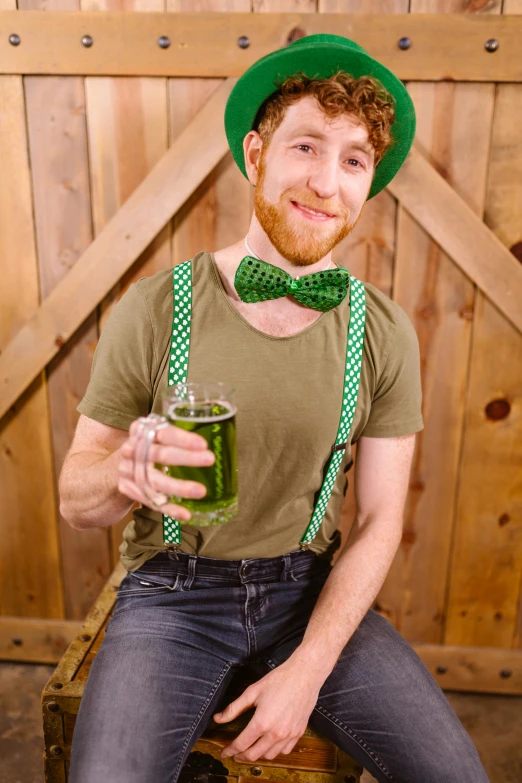 a man sitting on a chair holding a glass of beer, green halter top, bow tie, clover, trending photo