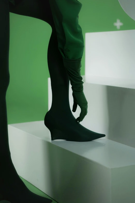 a woman standing on top of a white platform, inspired by Gao Cen, monochromatic green, shows a leg, vfx render, boots