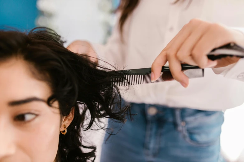 a woman cutting another woman's hair with a comb, by Nicolette Macnamara, trending on pexels, hurufiyya, thumbnail, over the shoulder, bedhead, woman with black hair