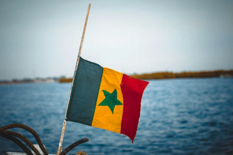 a flag that is on a boat in the water, pexels, figuration libre, dakar, green and gold, square, hi resolution