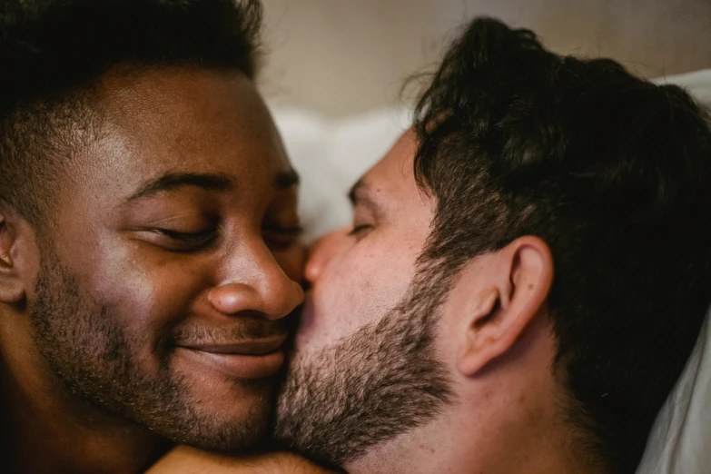 a couple of men laying in bed next to each other, trending on pexels, romanticism, kiss mouth to mouth, varying ethnicities, close - up photograph, profile image