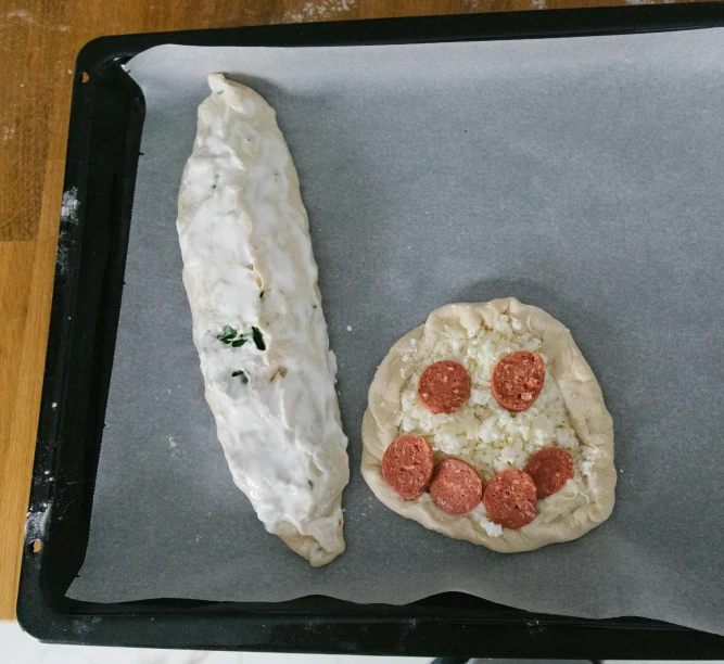 a pizza sitting on top of a pan on top of a table, dough sculpture, with a long white, weenie, half done
