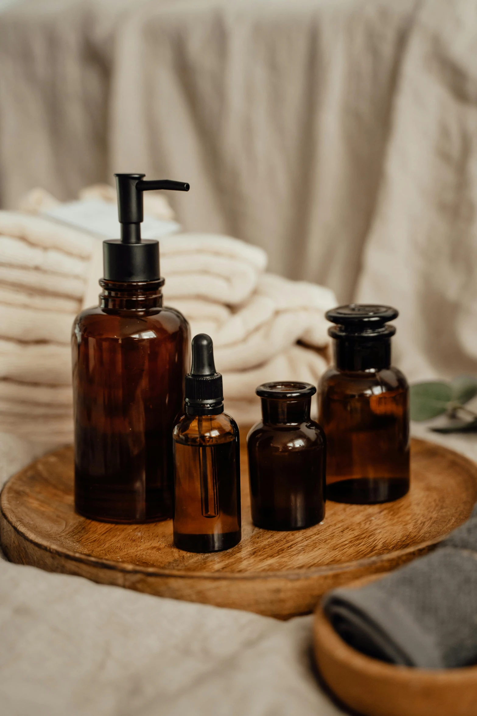 a bunch of bottles sitting on top of a wooden tray, a still life, unsplash, skin care, brown, black, amber