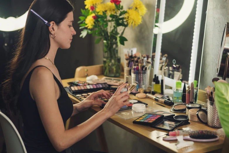 a woman sitting at a desk in front of a mirror, lots of makeup, profile image, multicoloured, practical effects
