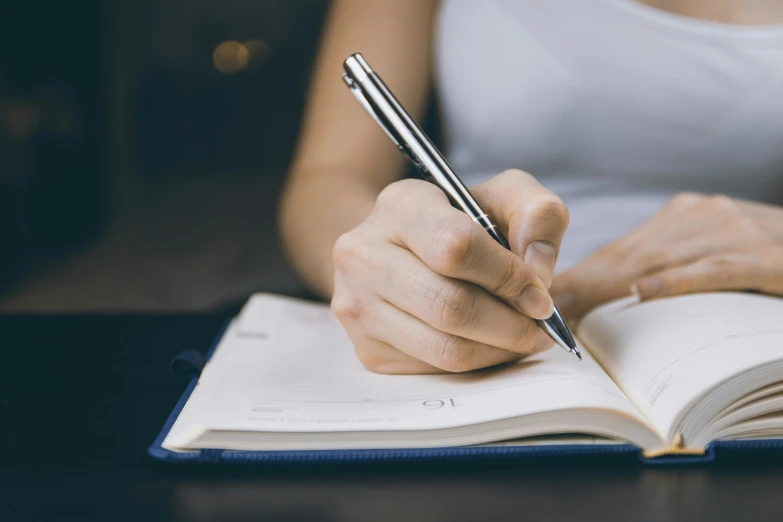 a woman holding a pen and writing in a notebook, pexels contest winner, te pae, multiple stories, taken in the early 2020s, avatar image