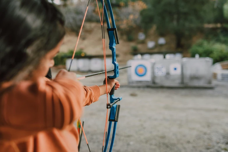 a close up of a person holding a bow and arrow, pexels contest winner, 🦩🪐🐞👩🏻🦳, local gym, a round minimalist behind, lachlan bailey