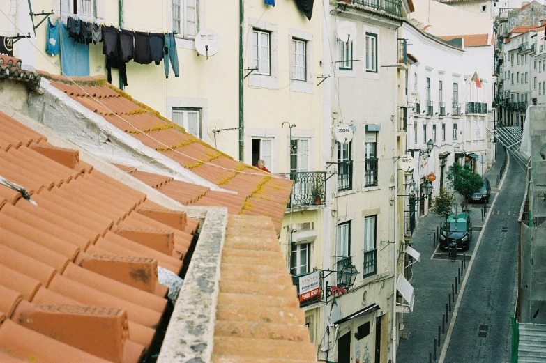 a city street filled with lots of tall buildings, a photo, by Emma Andijewska, portugal, hiding in the rooftops, al fresco, fine art print