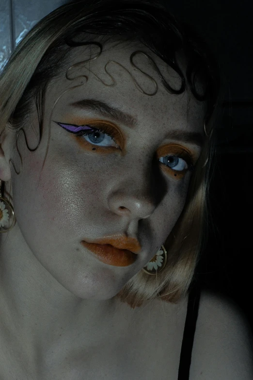 a close up of a person with makeup on, a colorized photo, inspired by Elsa Bleda, trending on pexels, orange halo, petra collins and mc. escher, white facepaint, young woman