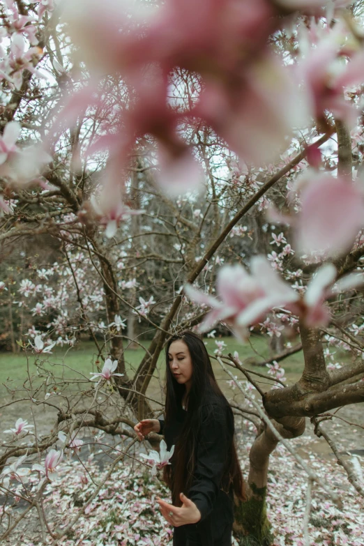 a woman standing in front of a tree with pink flowers, pexels contest winner, conceptual art, magnolia, portrait of mulan, food, still from a music video