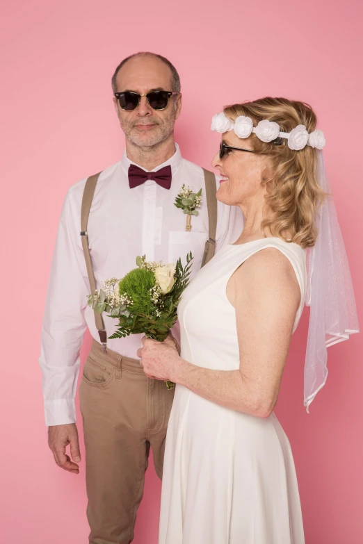 a man and a woman standing next to each other, a photo, by Sara Saftleven, solid color backdrop, my dress-up darling, white glasses, official store photo