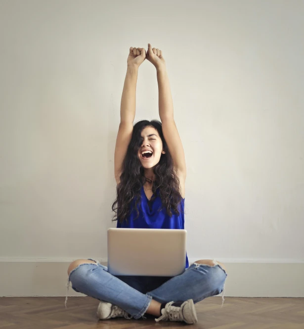 a woman sitting on the floor with her arms in the air, pexels, happening, sitting at a computer, celebrate goal, proud looking, teenage girl