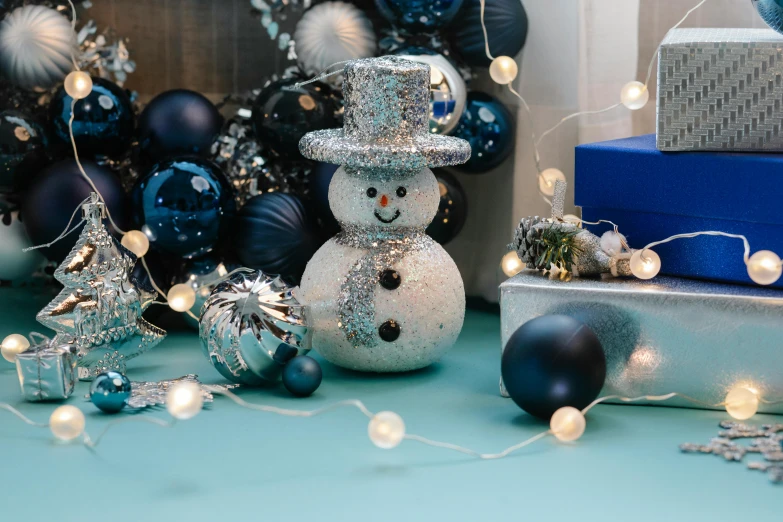 a close up of a snowman on a table, blue and silver, thumbnail, multiple lights, silver accessories