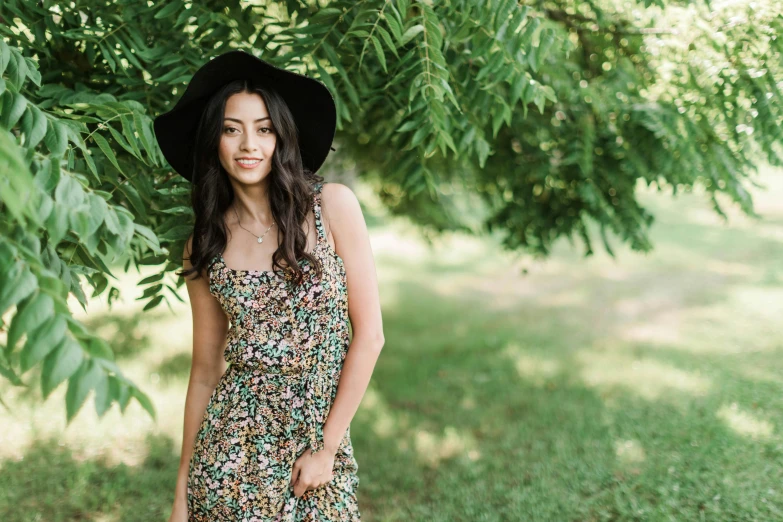 a woman standing under a tree in a dress and hat, a portrait, by Julia Pishtar, pexels, arabesque, :: madison beer, phoebe tonkin, an olive skinned, floral