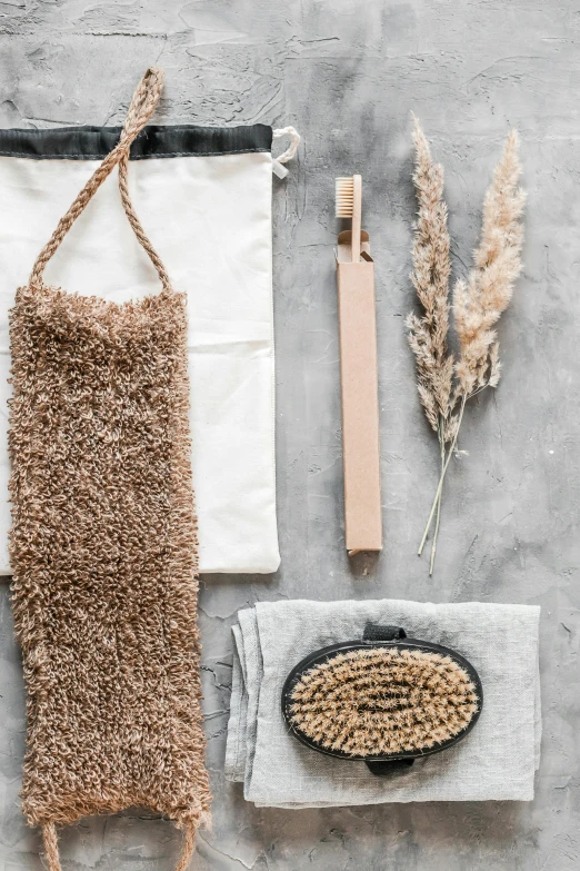 a towel, brush and other items laid out on a table, by Jan Tengnagel, unsplash, intricate copper details, hanging, textured base ; product photos, hemp