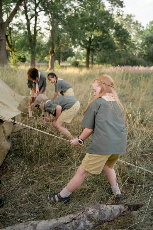 a group of people that are standing in the grass, camping, pulling strings, scout boy, ignant