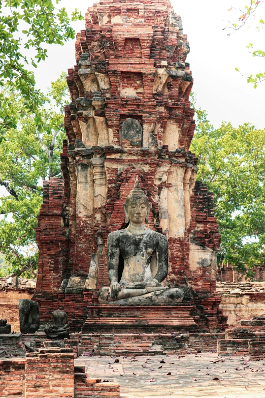 a statue sitting on top of a brick structure, temple ruins, thailand, square, facing front