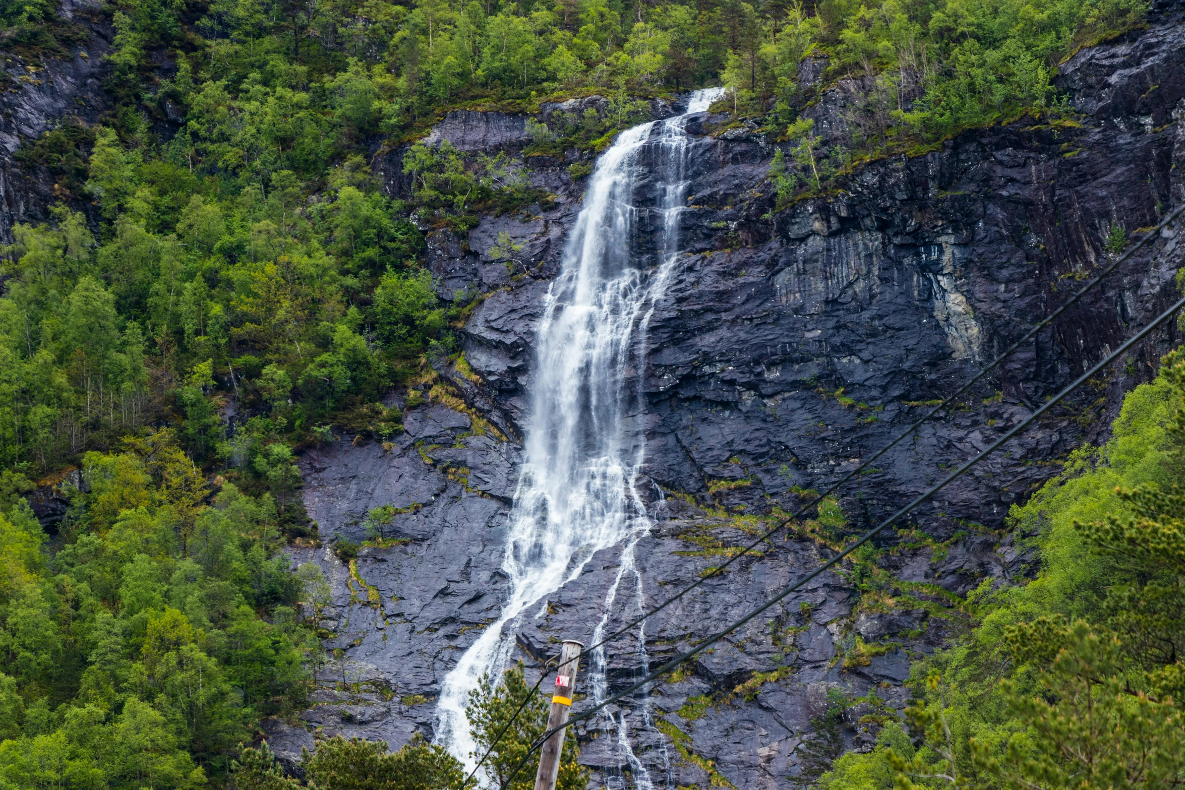 a large waterfall in the middle of a lush green forest, by Terese Nielsen, pexels contest winner, hurufiyya, “ iron bark, chairlifts, fjord, avatar image