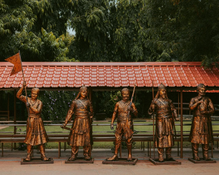 a group of bronze statues standing next to each other, a statue, inspired by Ram Chandra Shukla, pexels contest winner, samikshavad, time travelers appear in a park, warrior armor and weapons, miniatures, group of seven