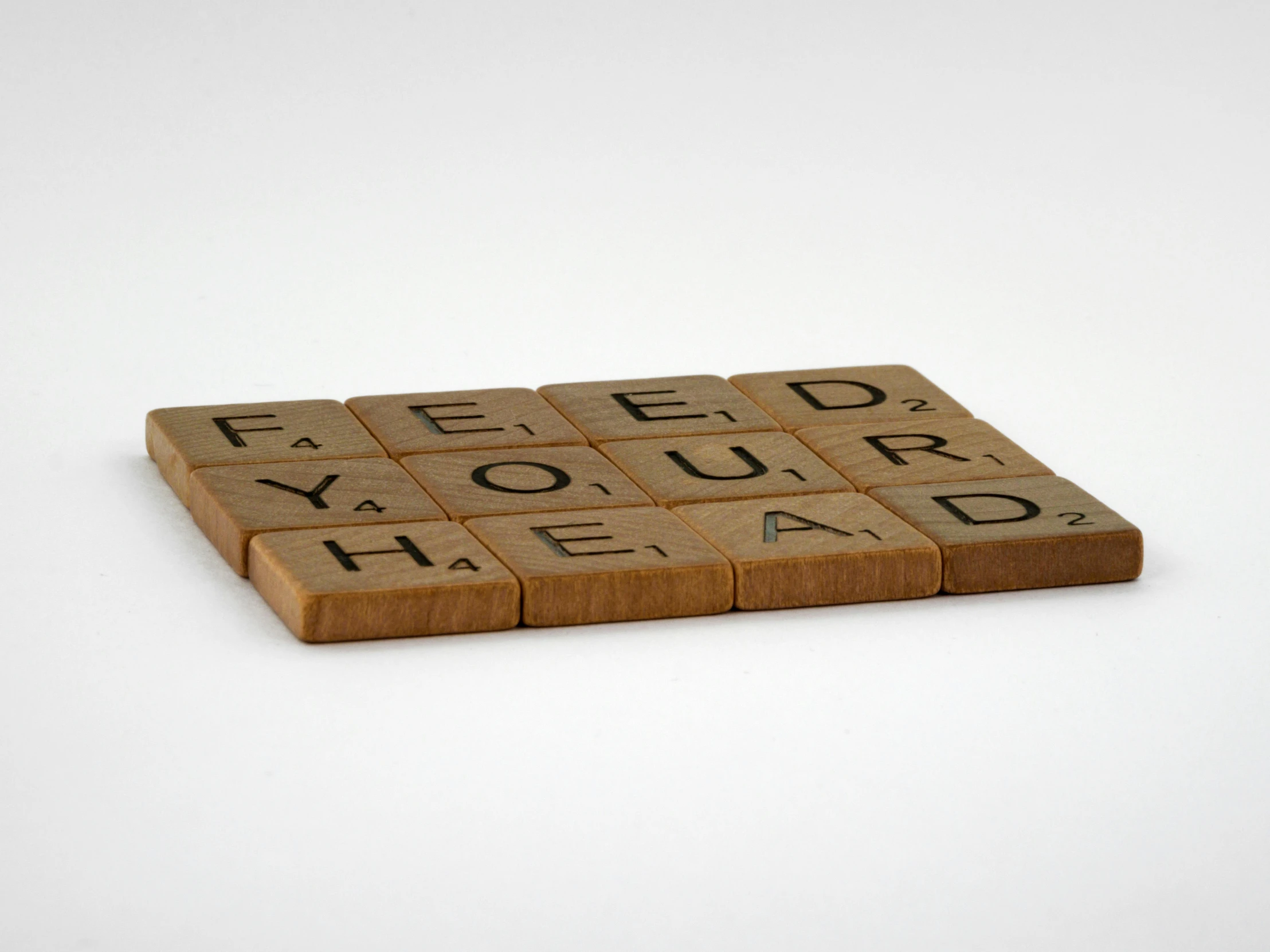 a scrabble with the words feed your head on it, inspired by Ian Hamilton Finlay, letterism, threea toys, brown, food, easy to use