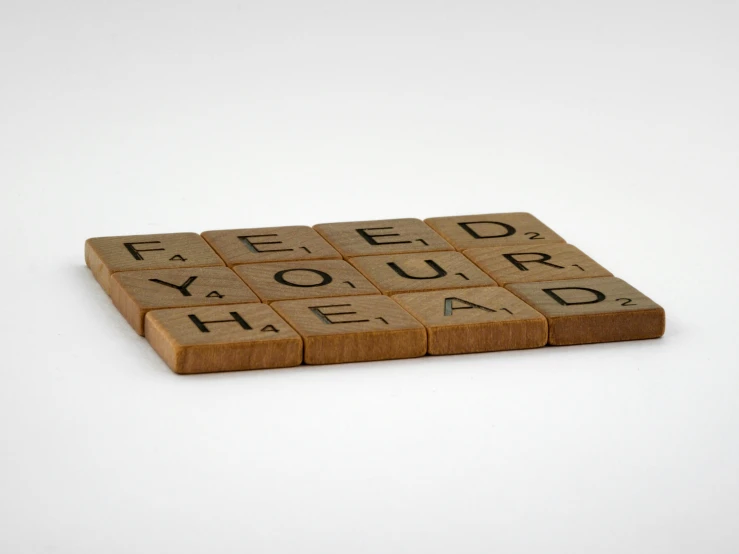 a scrabble with the words feed your head on it, inspired by Ian Hamilton Finlay, letterism, threea toys, brown, food, easy to use