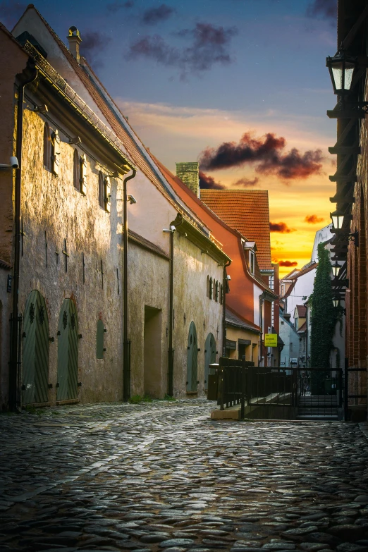 a cobblestone street with a bench in the middle, pexels contest winner, romanesque, sunset golden hour hues, capital of estonia, red roofs, square