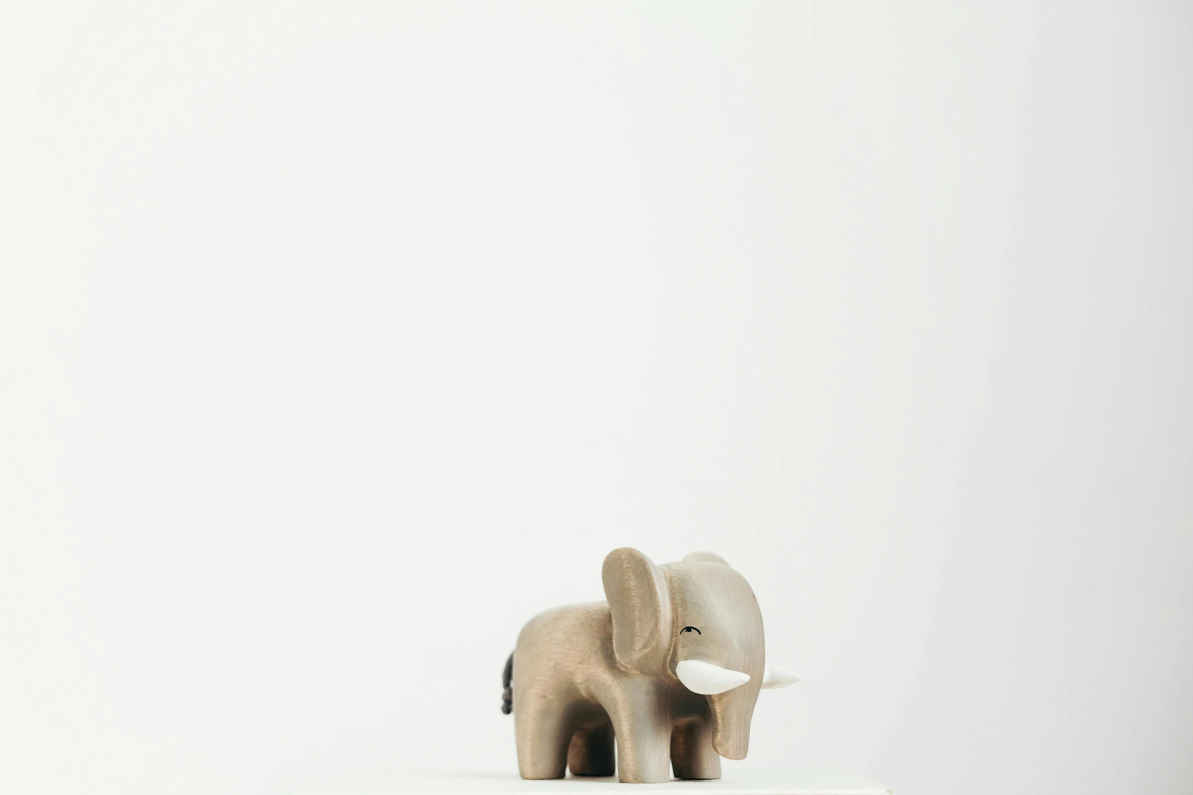 an elephant figurine sitting on top of a cake, trending on unsplash, figuration libre, wooden art toys, on a white table, detailed product image, standing on a shelf