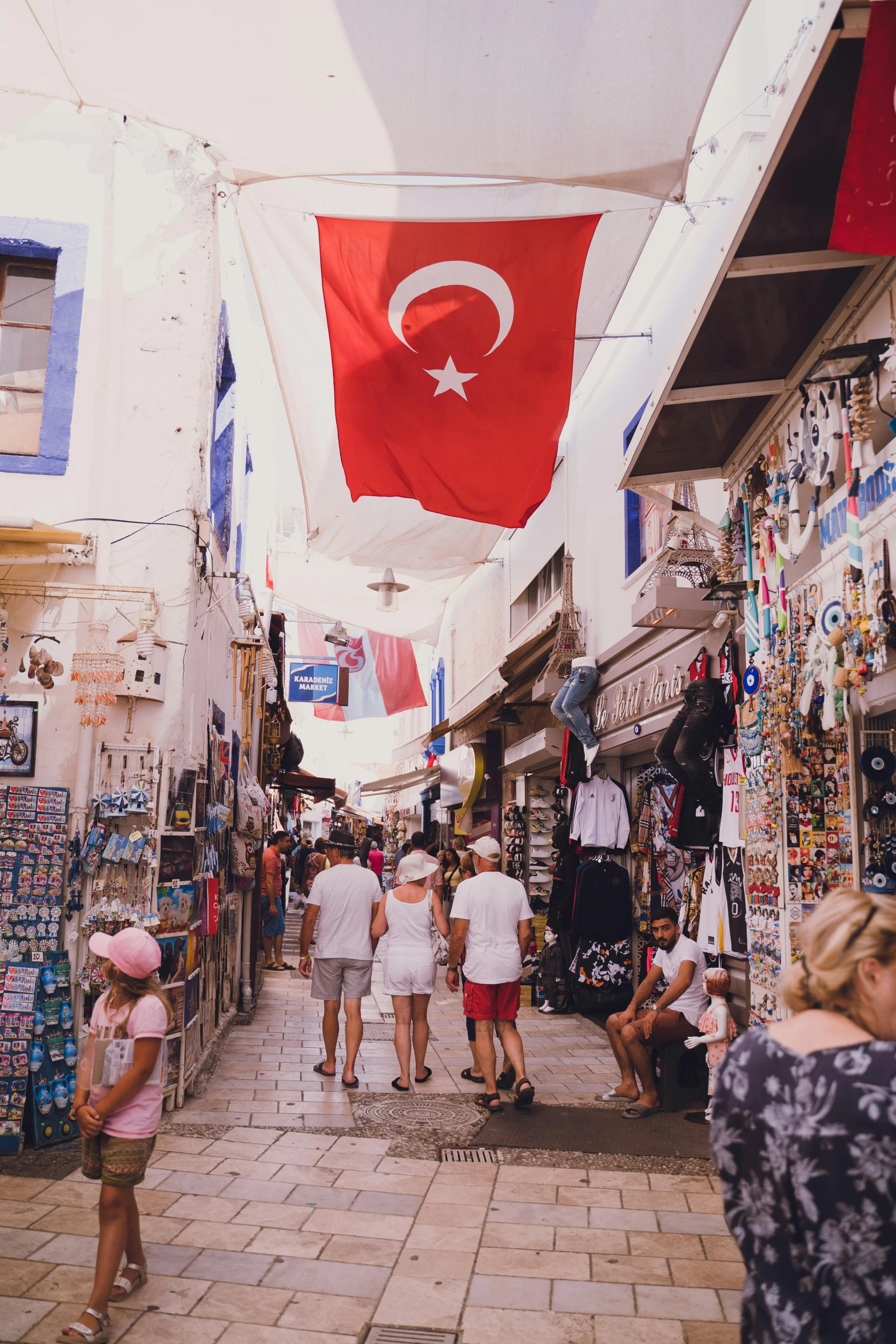 a group of people walking down a narrow street, trending on pexels, flags, turkey, 🚿🗝📝