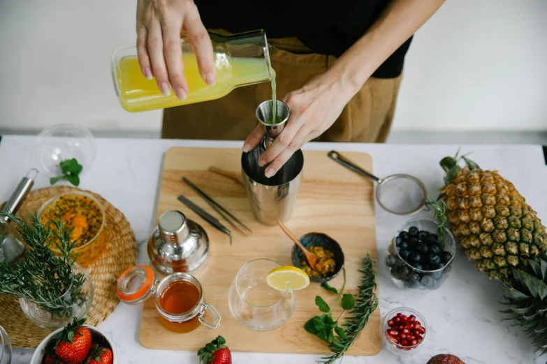 a person pouring orange juice into a glass, a still life, pexels, stainless steal, berry juice, thumbnail, ingredients on the table