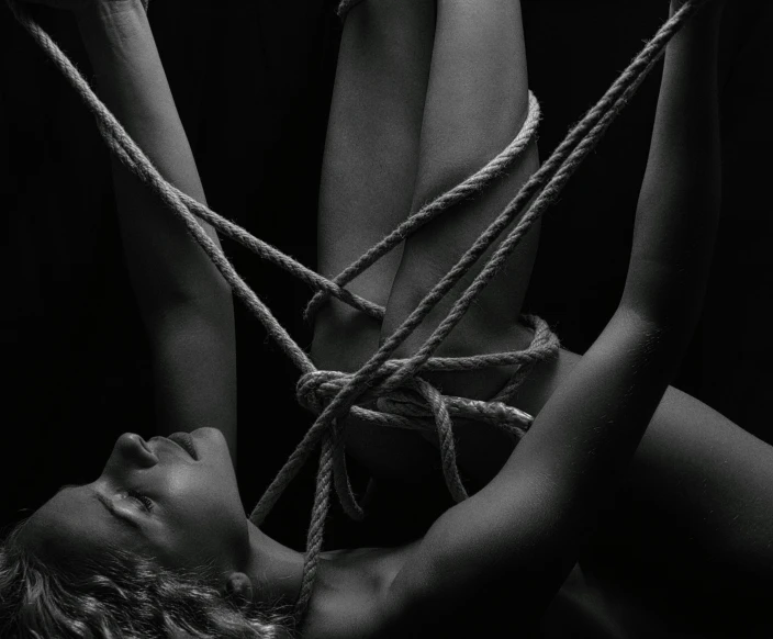 a black and white photo of a woman tied up, pexels contest winner, human bodies intertwined, album cover, rope, caravaggesque style