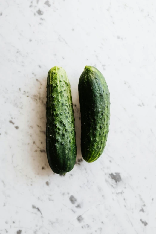 two cucumbers sitting next to each other on a table, unsplash, jen atkin, high quality product image”, portrait n - 9, front and side view