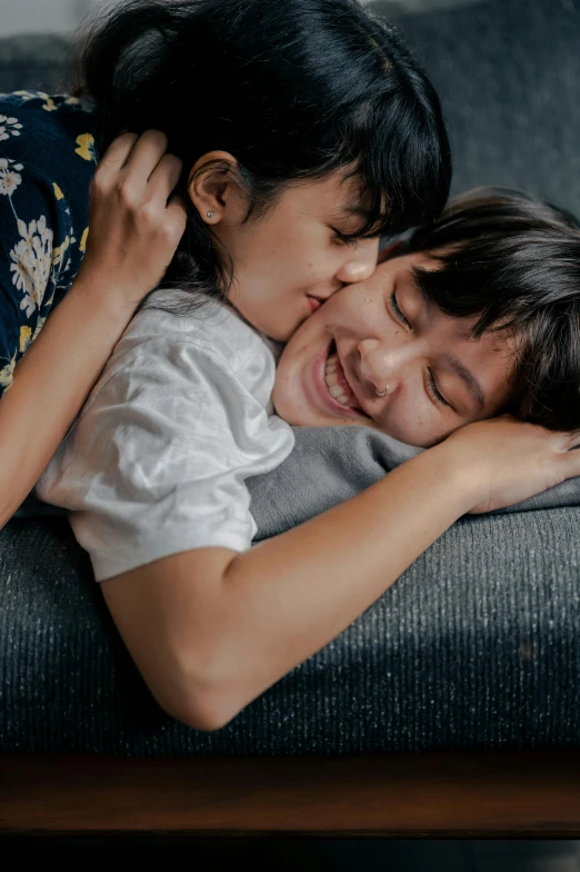 a couple of people laying on top of a couch, pexels contest winner, incoherents, portrait of two girls kissing, joy ang, motherly, profile image