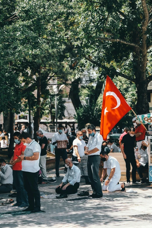 a group of people that are standing in the street, a cartoon, by irakli nadar, pexels contest winner, hurufiyya, holding a white flag, turkey, sitting on the ground, square