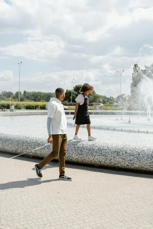 a man and a woman walking a dog in front of a fountain, by Daniel Gelon, trending on unsplash, visual art, kids, northern france, mies van der rohe, sunny day time