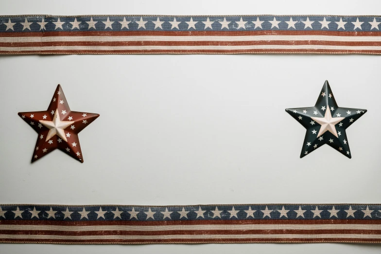 three red, white and blue stars hanging on a wall, an album cover, by Carey Morris, pexels, metal border, vintage - w 1 0 2 4, on a white table, american flag