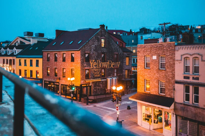a city street filled with lots of tall buildings, by Julia Pishtar, pexels contest winner, yellow awning, victorian harbour night, quebec, standing on a rooftop